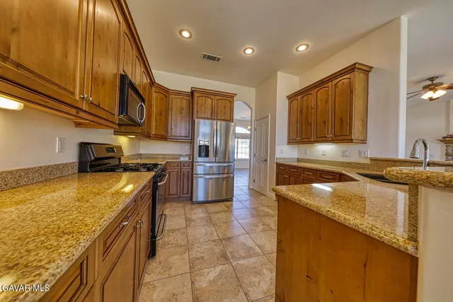 a kitchen with stainless steel appliances granite countertop a sink and cabinets