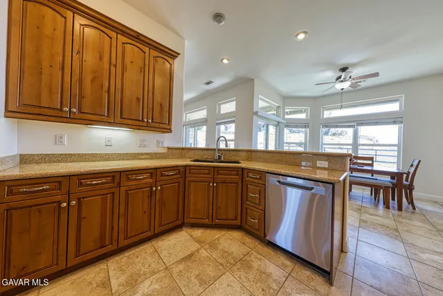 a kitchen with stainless steel appliances granite countertop a refrigerator stove and sink