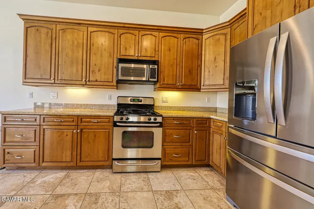 a kitchen with stainless steel appliances granite countertop a stove a sink and a microwave