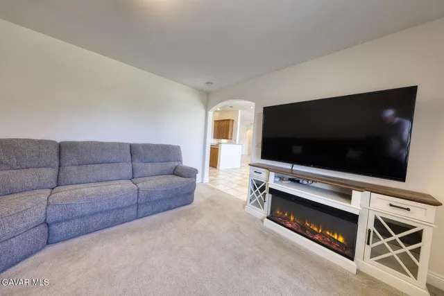 a spacious bedroom with a bed a chandelier and a dresser