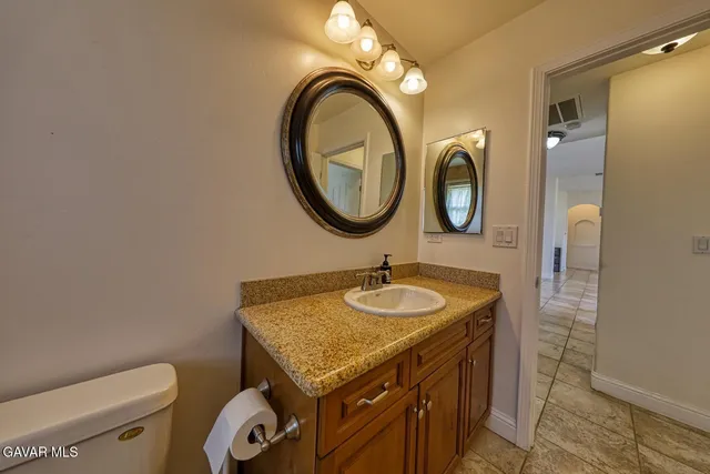 a bathroom with a granite countertop sink and a mirror