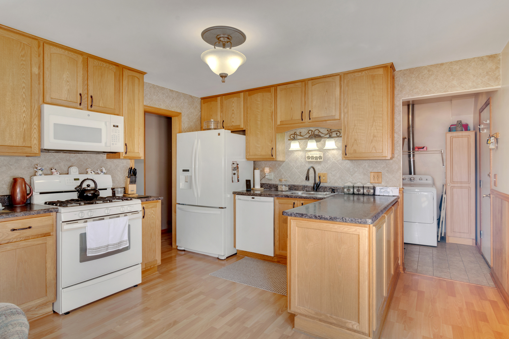 72 Marnel Road Montgomery, IL 60538 - Photo 7 of 26 a kitchen with a sink a stove a refrigerator and cabinets
