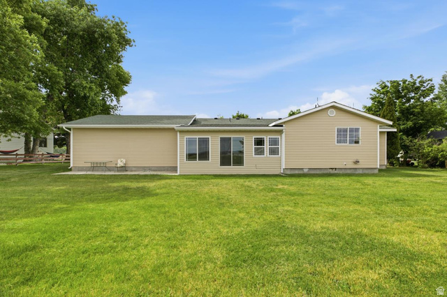 435 East 4th North Preston, ID 83263 - Photo 18 of 26 Expansive green lawn with a tan siding exterior and green shingle roofing