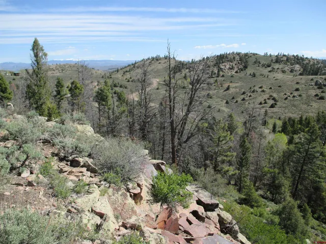 a view of a building with a mountain and trees in the background