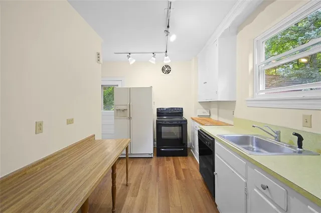 a kitchen with a sink a counter top space stainless steel appliances and a window