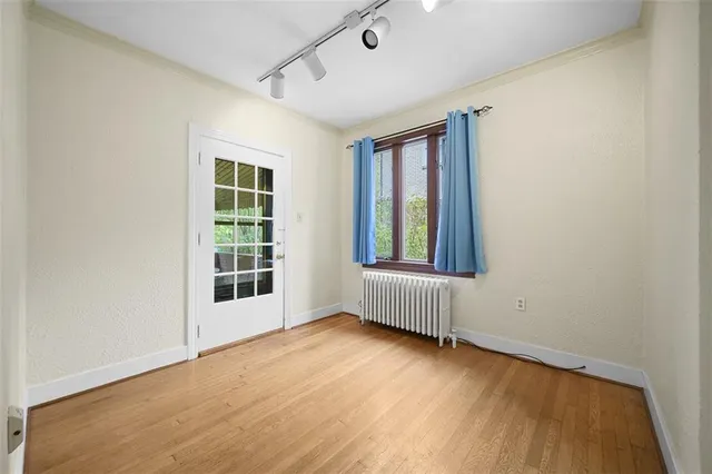 an empty room with wooden floor and windows