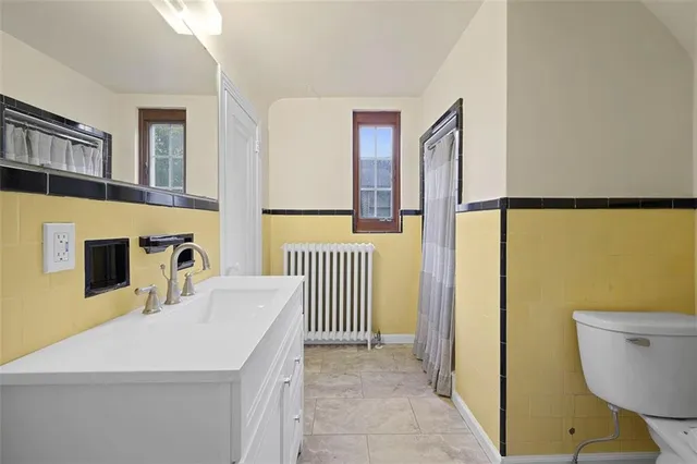 a bathroom with a sink a toilet and a mirror