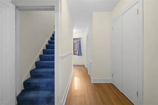 a view of a hallway with wooden floor and entryway
