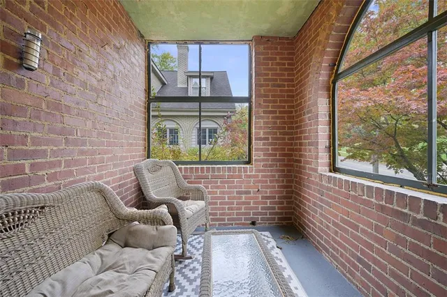 a view of a brick house with a chairs in balcony