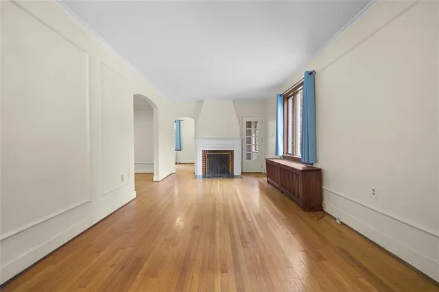 wooden floor fireplace and windows in an empty room
