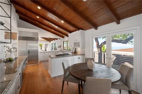 a kitchen with stainless steel appliances granite countertop sink stove top oven table and chairs