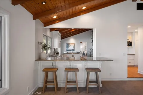 a dining room with kitchen island furniture a chandelier and kitchen view