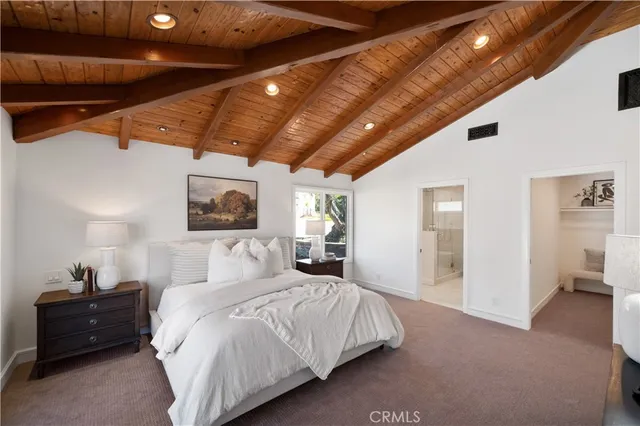 a spacious bedroom with a bed and a chandelier