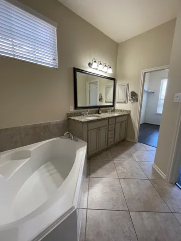 a bathroom with a tub sink and mirror