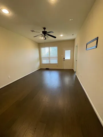 an empty room with windows and cabinet