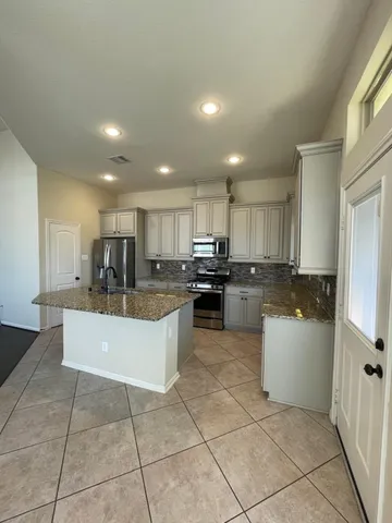 a large kitchen with a counter top stainless steel appliances and cabinets