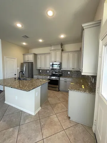 a kitchen with stainless steel appliances granite countertop a sink refrigerator and microwave