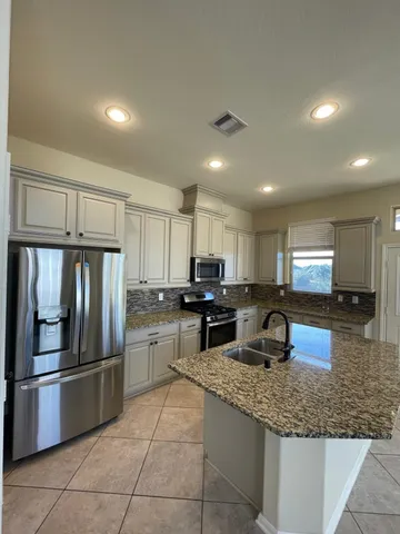 a kitchen with stainless steel appliances granite countertop a sink refrigerator and microwave