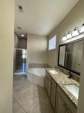 a bathroom with a granite countertop bathtub sink and mirror