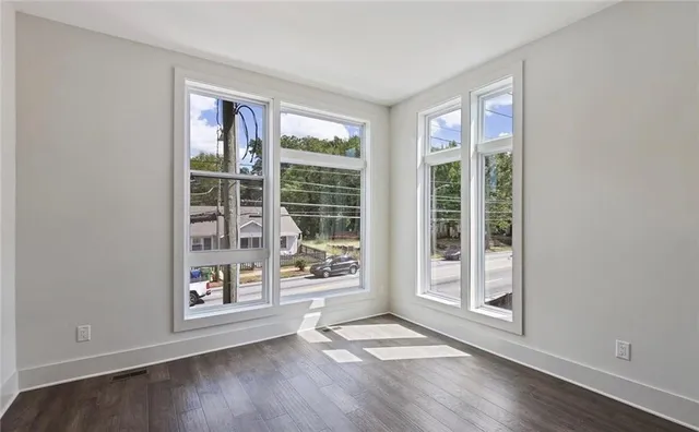 an empty room with wooden floor and windows
