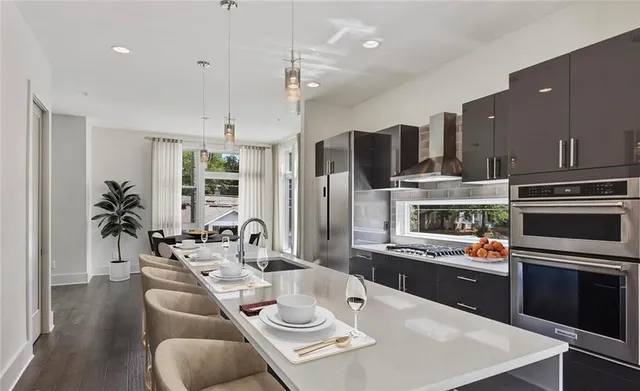 a open kitchen with stainless steel appliances kitchen island granite countertop a dining table and chairs