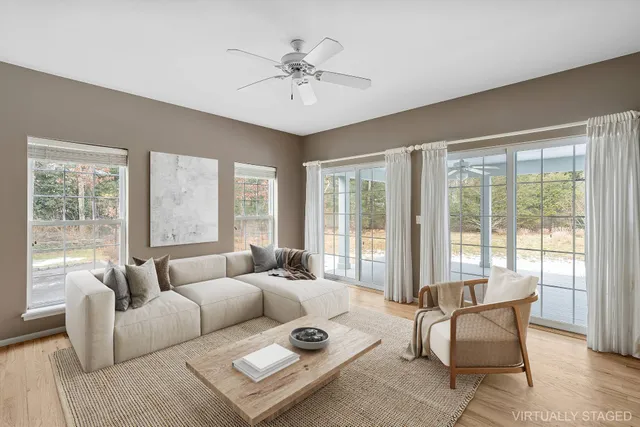a living room with furniture and floor to ceiling windows
