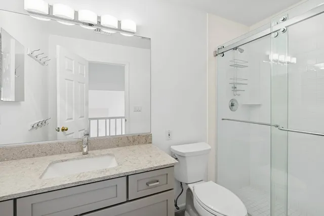 a bathroom with a granite countertop sink toilet and shower