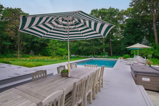 a view of a roof deck with table and chairs under an umbrella