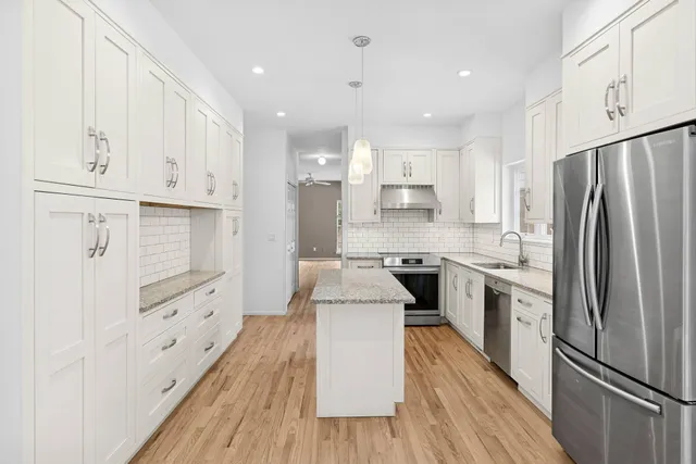 a kitchen with white cabinets and stainless steel appliances