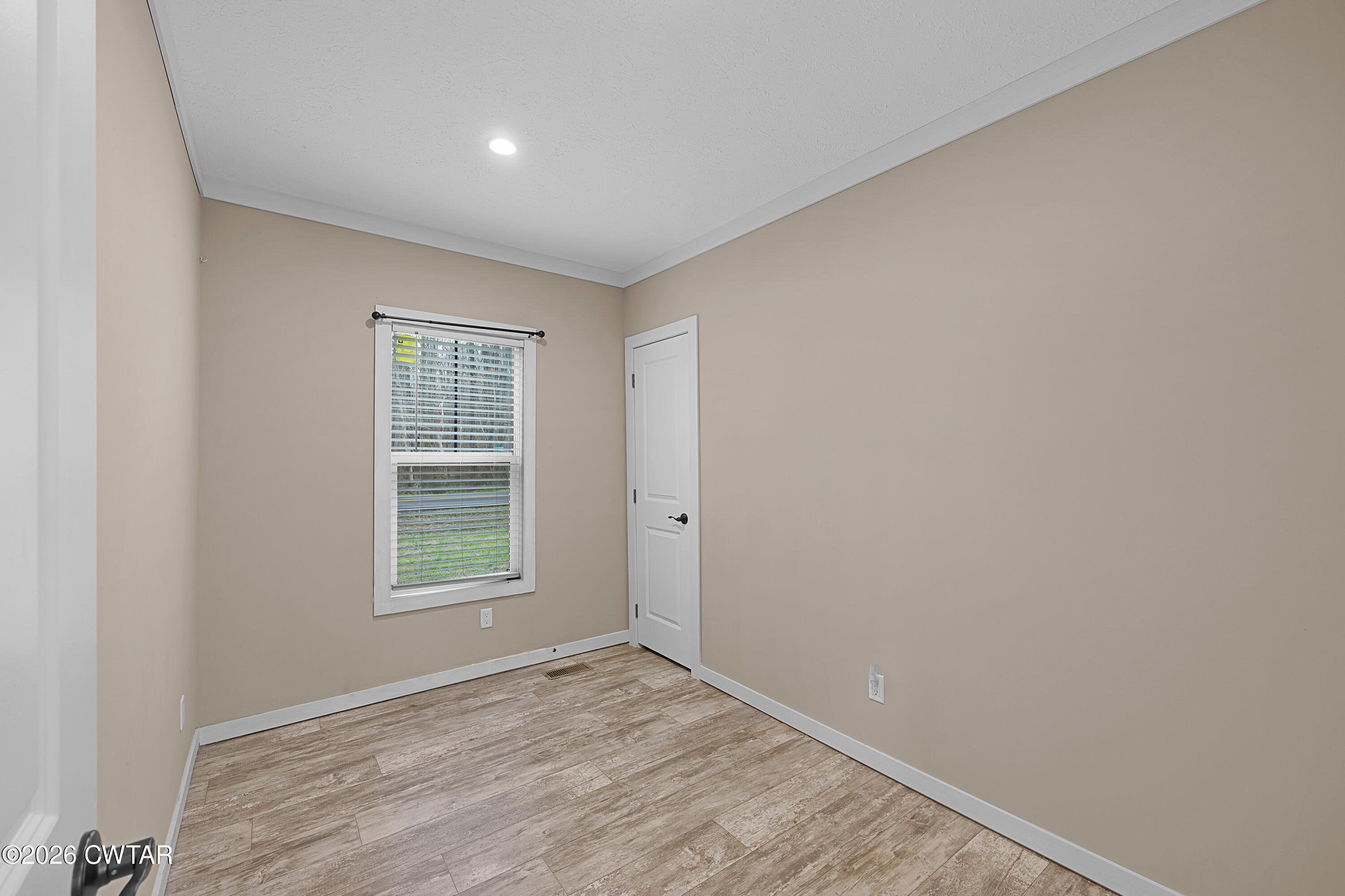 461 Humboldt Gibson Wells Road Humboldt, TN 38343 - Photo 13 of 24 an empty room with wooden floor and windows