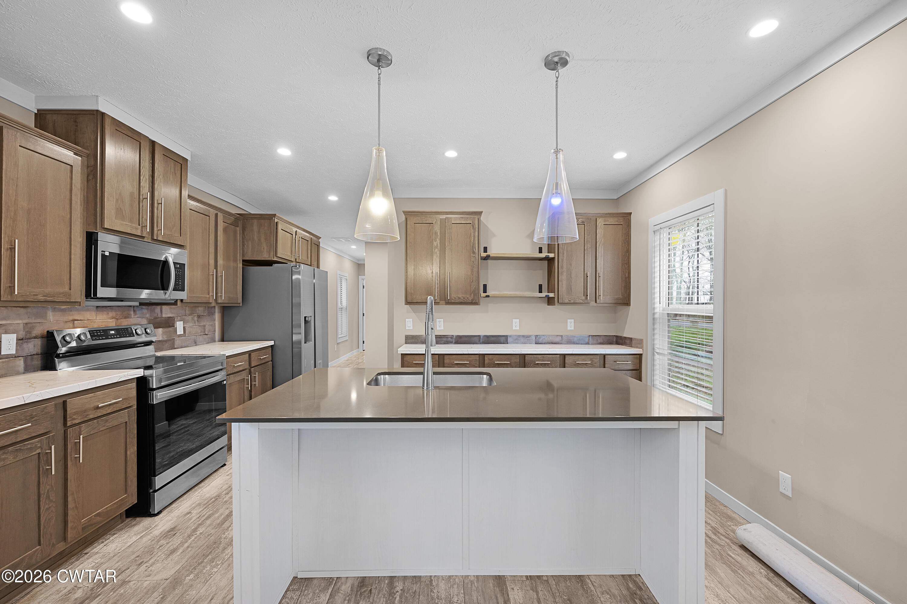 461 Humboldt Gibson Wells Road Humboldt, TN 38343 - Photo 2 of 24 a kitchen with kitchen island a sink stainless steel appliances and cabinets