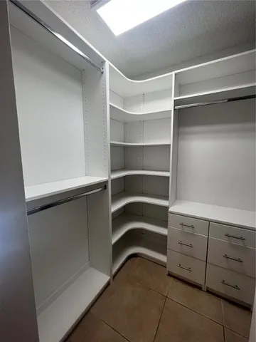 a view of walk in closet with empty racks