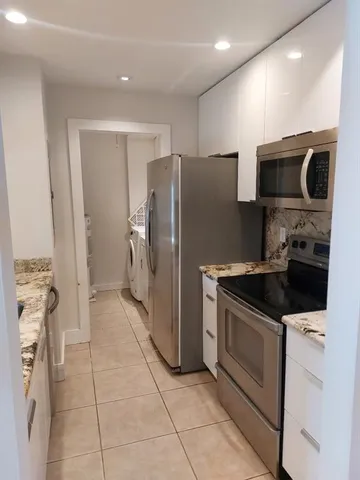 a kitchen with stainless steel appliances granite countertop a refrigerator and a stove