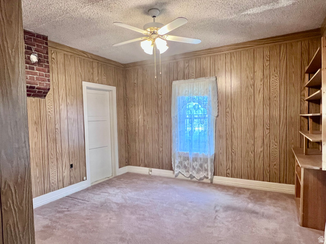 479 East 100 N Road Meadow, UT 84644 - Photo 16 of 59 Carpeted empty room with a textured ceiling, ceiling fan, and wooden walls