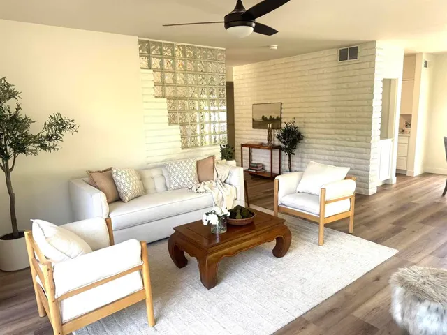 an empty room with wooden floor mirror and windows