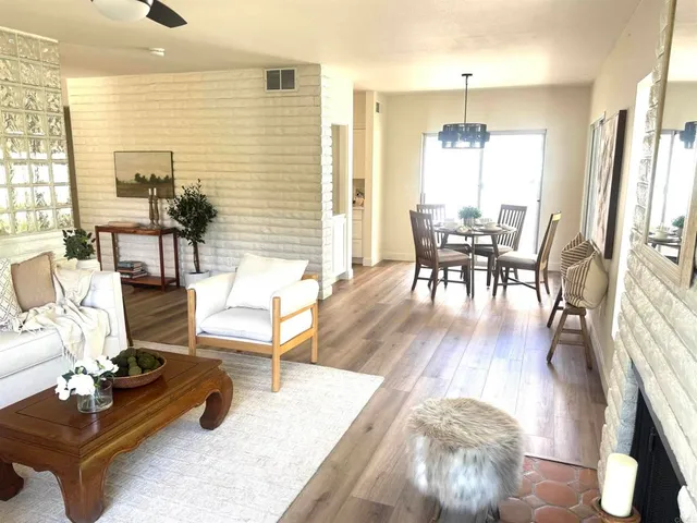 a dining room with furniture potted plants and wooden floor