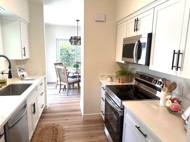 a kitchen with stainless steel appliances a sink stove and cabinets