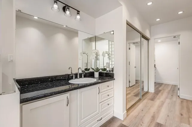 a bathroom with double vanity white cabinets and a mirror