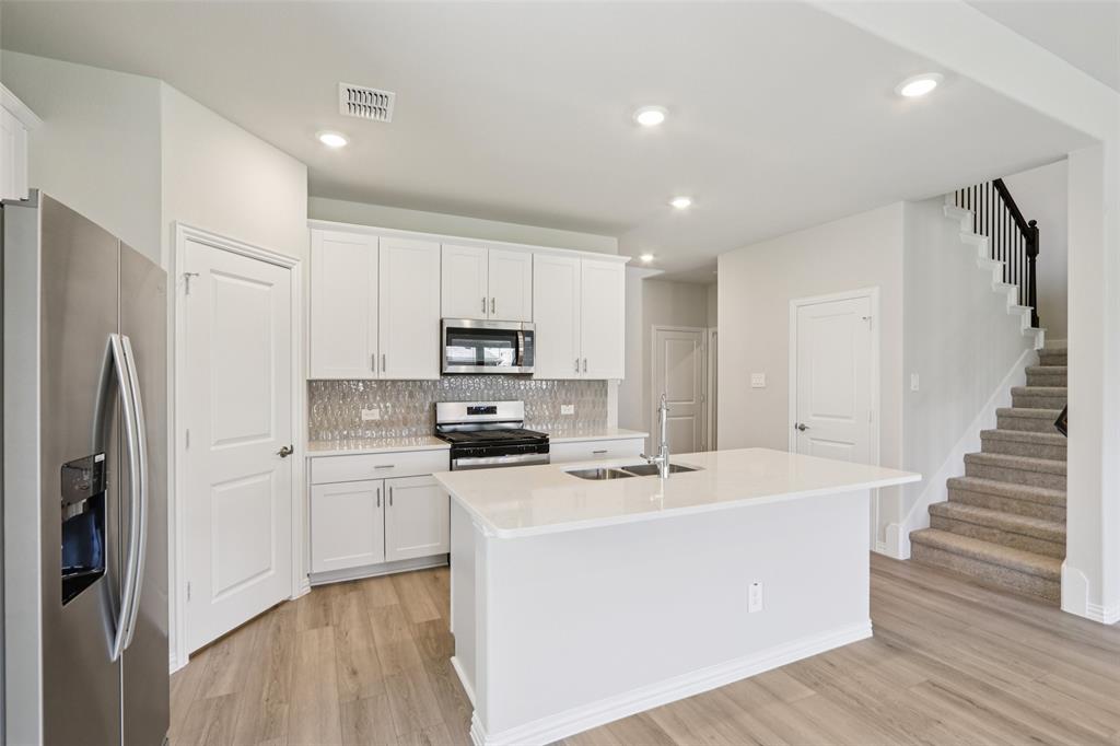 2709 Grand Cyn Street Anna, TX 75409 - Photo 14 of 40 a kitchen with stainless steel appliances a refrigerator sink and microwave