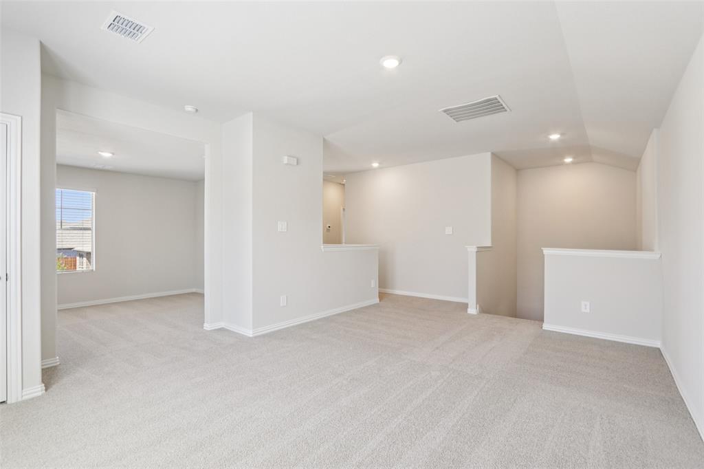 2709 Grand Cyn Street Anna, TX 75409 - Photo 29 of 40 an empty room with white walls and kitchen space