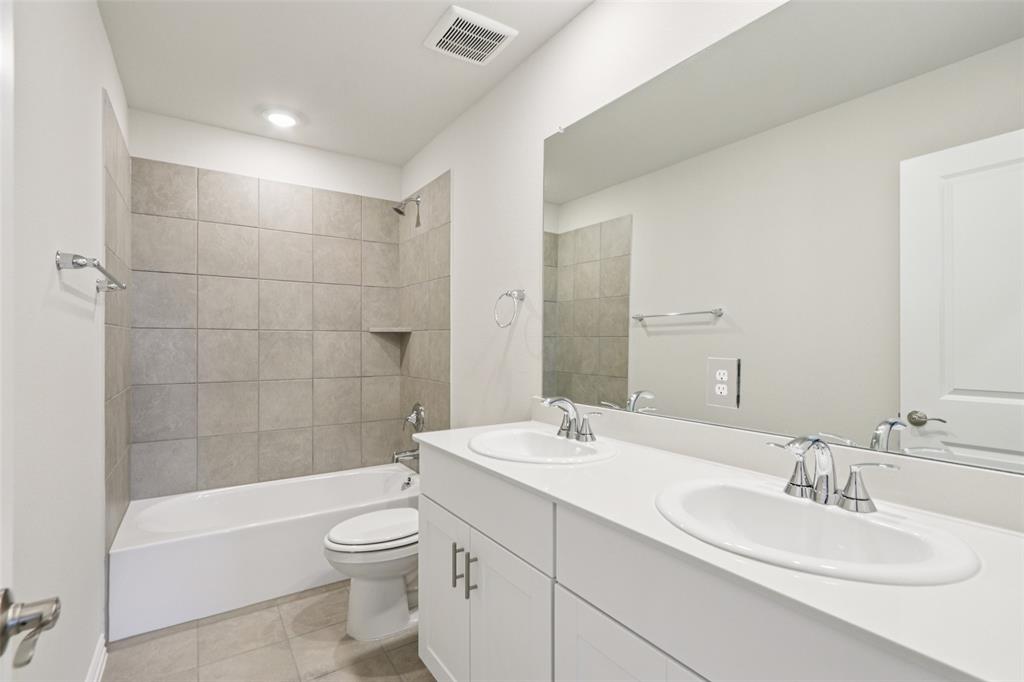 2709 Grand Cyn Street Anna, TX 75409 - Photo 32 of 40 a bathroom with a double vanity sink toilet mirror and bathtub