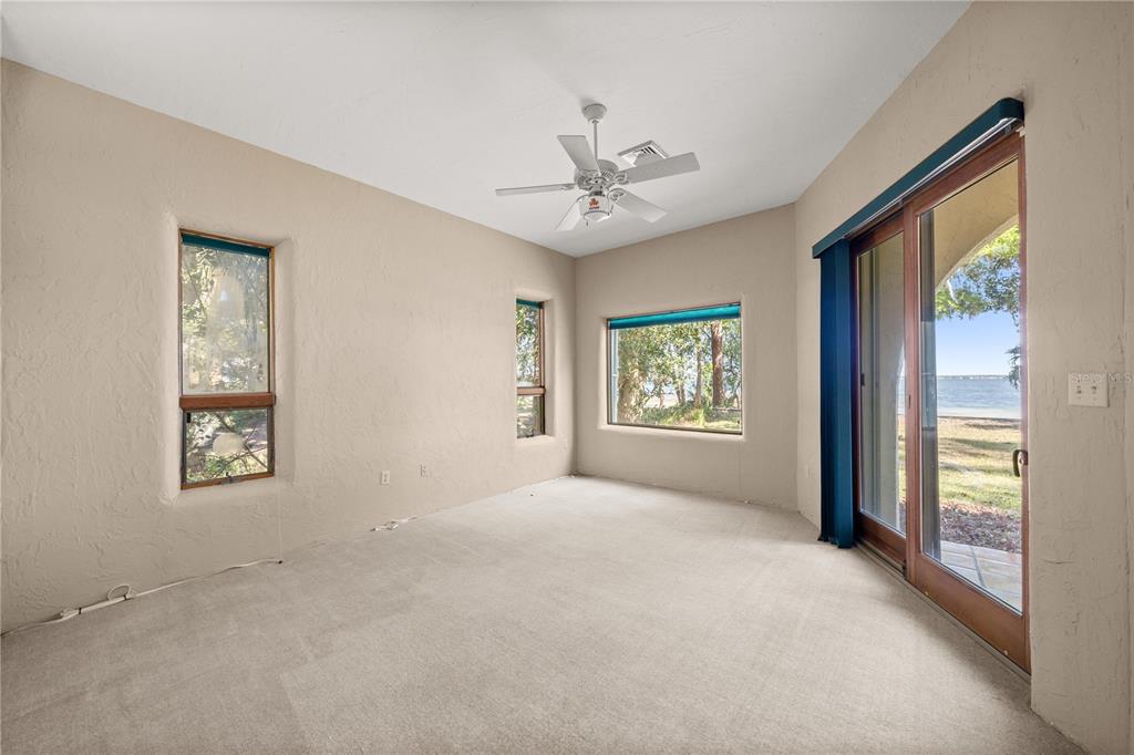 12621 Southeast Sunset Harbor Road Weirsdale, FL 32195 - Photo 22 of 54 a view of a big room with windows and chandelier fan