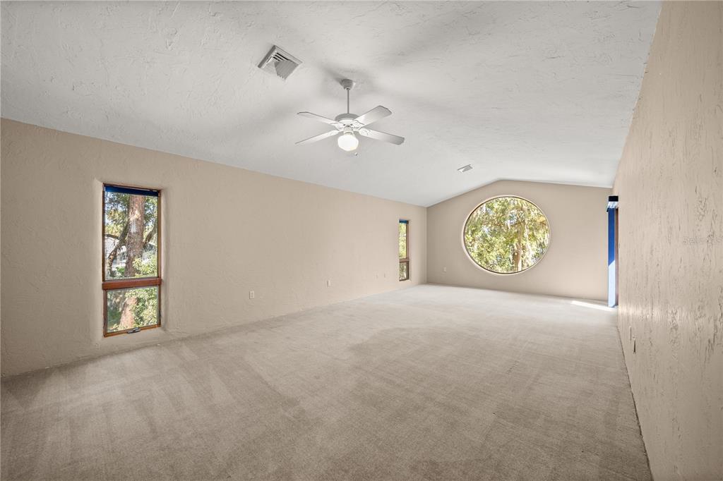 12621 Southeast Sunset Harbor Road Weirsdale, FL 32195 - Photo 27 of 54 an empty room with windows and fan