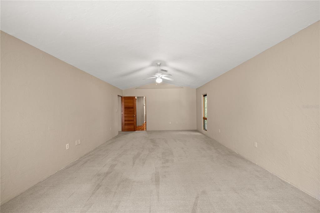 12621 Southeast Sunset Harbor Road Weirsdale, FL 32195 - Photo 30 of 54 en empty room with a ceiling fan and window