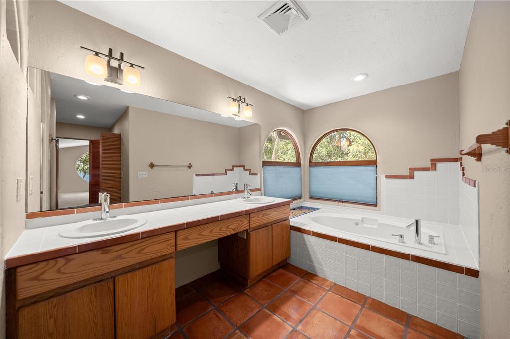 12621 Southeast Sunset Harbor Road Weirsdale, FL 32195 - Photo 31 of 54 a large bathroom with a double vanity sink mirror and bathtub