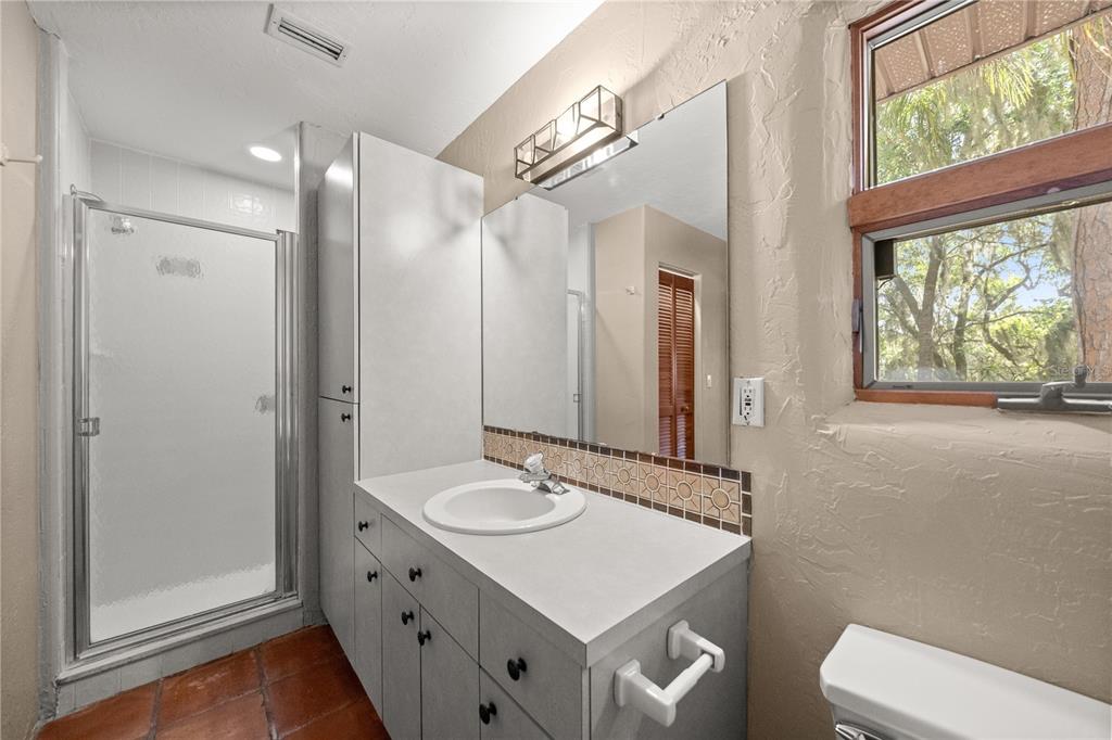 12621 Southeast Sunset Harbor Road Weirsdale, FL 32195 - Photo 37 of 54 a bathroom with a sink toilet double vanity and window