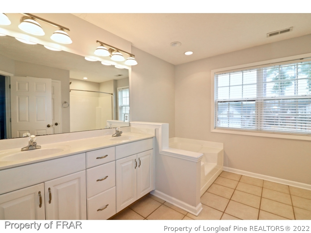 45 Chesapeake Road Cameron, NC 28326 - Photo 29 of 35 a spacious bathroom with a double vanity sink a large mirror and a