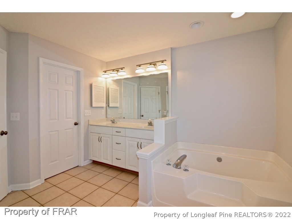 45 Chesapeake Road Cameron, NC 28326 - Photo 30 of 35 a bathroom with a tub a sink and a mirror
