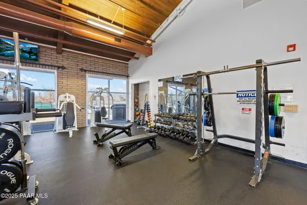 a kitchen with kitchen island granite countertop a stove top oven a sink dishwasher and white cabinets with wooden floor