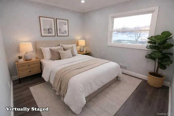 a bedroom with a bed and a potted plant